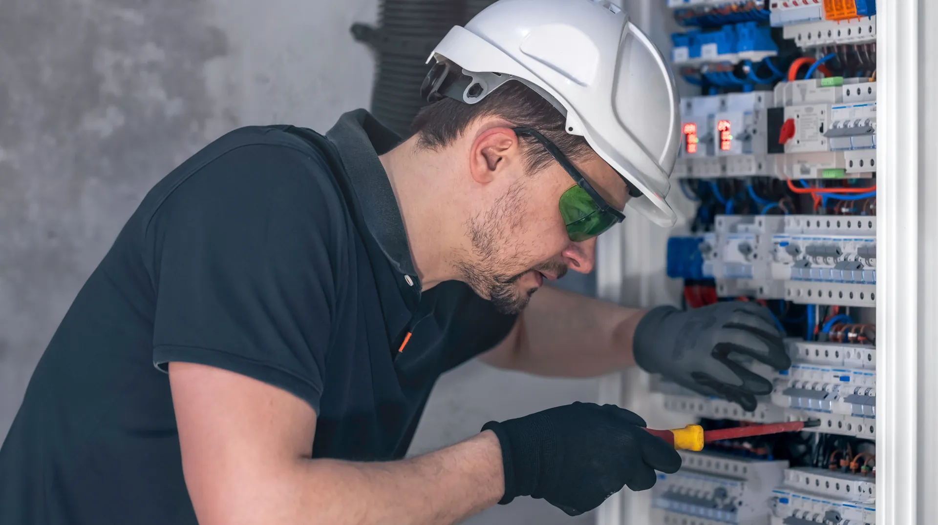Electrician working on a residential electrical panel as a home service professionals in the us.